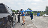 Sioux Lookout Mayor Doug Lawrance (left), Kenora MP Eric Melillo (centre), and Blueberry Festival mascot Blueberry Bert greet guests and offer cupcakes and festival events booklets as part of the Blueberry Festival’s Opening Ceremonies on July 30.     Ree