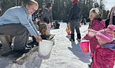 Sioux Lookout Public Library Assistant Librarian, and Friends of Cedar Bay volunteer, Nancy McCord (left) greets two visitors to this year’s Easter Egg Hunt at the Cozy Cabin on March 29. Children were able to exchange Easter Eggs they’d found for a candy