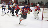Local police officers and local firefighters in action in last Saturday’s charity hockey game.     Tim Brody / Bulletin Photo