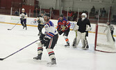 Local police officers and local firefighters in action in last Saturday’s charity hockey game.     Tim Brody / Bulletin Photo
