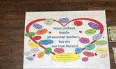 Customers at Fresh Market Foods, and other businesses in town are greeted by colourful signs that list and thank essential workers. - Tim Brody / Bulletin Photo