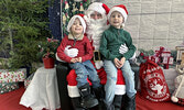 Brothers Everett Mandryk, 4, and Bronson Mandryk, 6, pose for a photo with Santa Claus after telling him what they would like for Christmas.     Tim Brody / Bulletin Photo