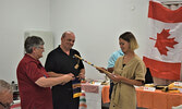 Petra Balczo (far right) receiving a miniature canoe paddle and a Rotary Club of Sioux Lookout banner from Rotary Club of Sioux Lookout member Susan Barclay (far left) and Club Past President Klaus Knorz. - Jesse Bonello / Bulletin Photos