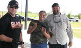 Second place winners BJ Egerter (right) and daughter Kendall Egerter (centre) hand their largest fish (3.78 pounds) to SLAH President Jeremy Funk (left) to be weighed.    Tim Brody / Bulletin Photo