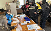 Sioux Lookout – Hudson Snowarama participant Galen Cushway (wearing snowmobile helmet, standing) checks in at the registration table for the event.     Tim Brody / Bulletin Photo
