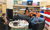 Students standing behind the couches, from left: Miah Morrisseau, Teacher Jane Kwabena, Keifer Rae, Keira Rae and Kian Courchrene, offer fruit cups to Elders, seated from left: Ida Rae, Joy Keewaykapow, and Gladys Ombash. - Rachel Ombash / Submitted Photo